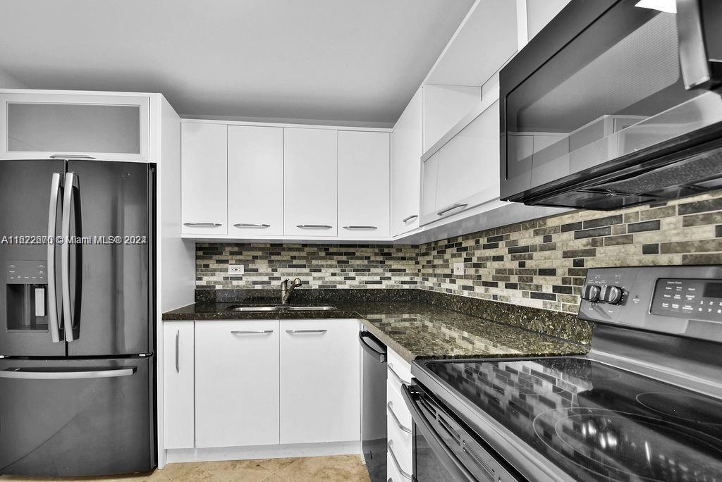 5555 Collins Avenue, Unit 5V Miami Beach, FL 33140 - Photo 14 of 46 a kitchen with stainless steel appliances granite countertop a stove and a refrigerator