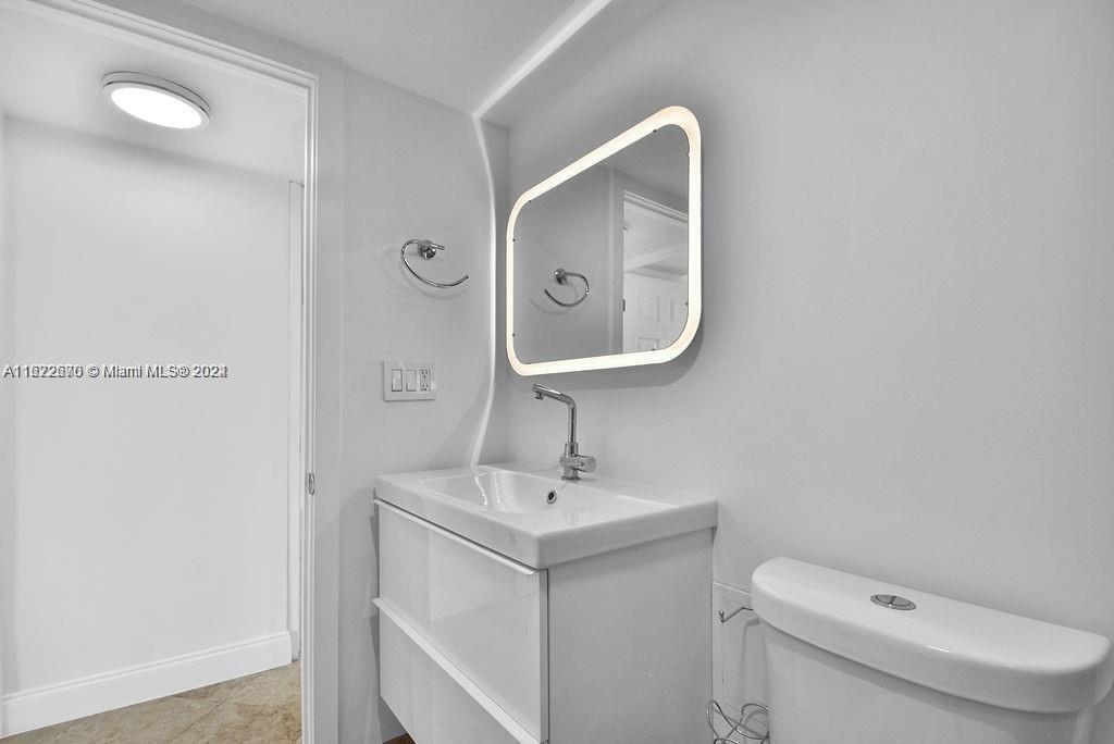 5555 Collins Avenue, Unit 5V Miami Beach, FL 33140 - Photo 27 of 46 a bathroom with a toilet sink and mirror