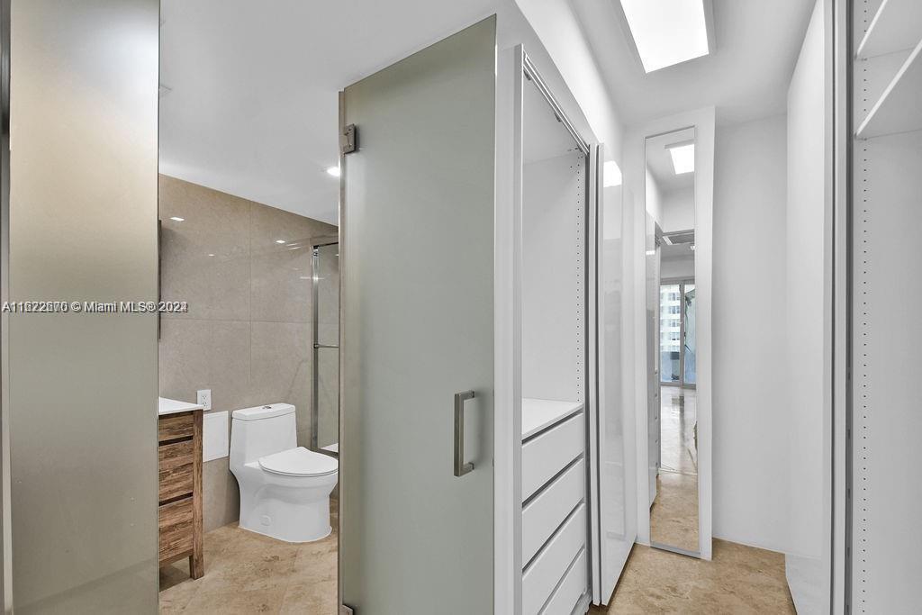 5555 Collins Avenue, Unit 5V Miami Beach, FL 33140 - Photo 10 of 46 a bathroom with a toilet a sink and shower