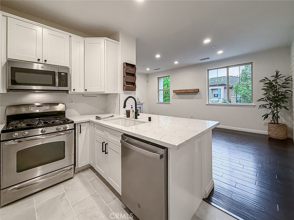 6834 Simmons Way Moorpark, CA 93021 - Photo 12 of 40 a kitchen with stainless steel appliances granite countertop a sink a stove a microwave and cabinets