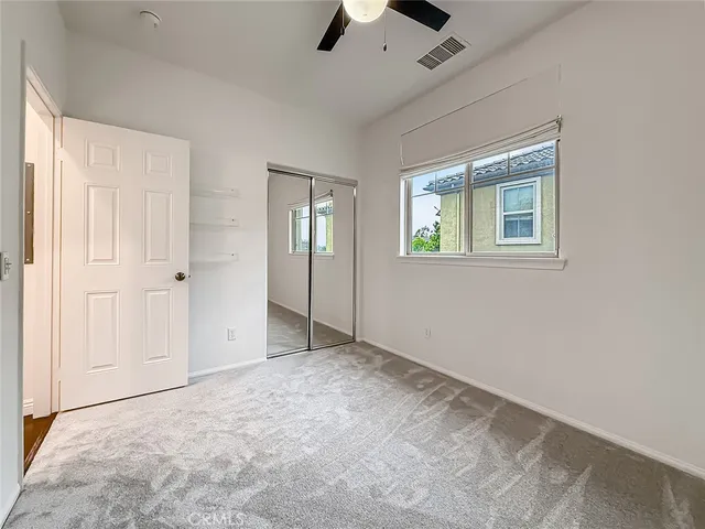 an empty room with fan and windows