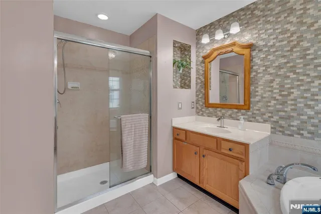 a bathroom with a double vanity sink mirror and shower