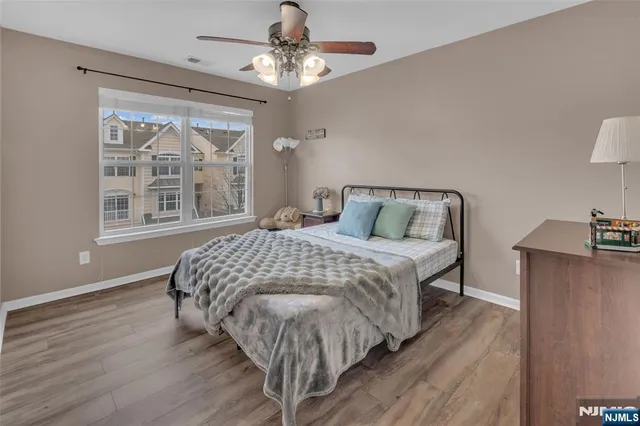 a bedroom with a large bed chandelier and a window