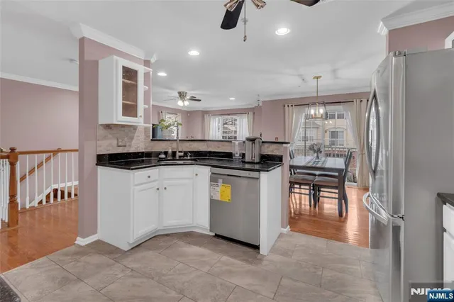 a kitchen with granite countertop a refrigerator a sink a stove and cabinets