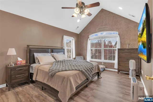 a bedroom with a bed wooden floor and window