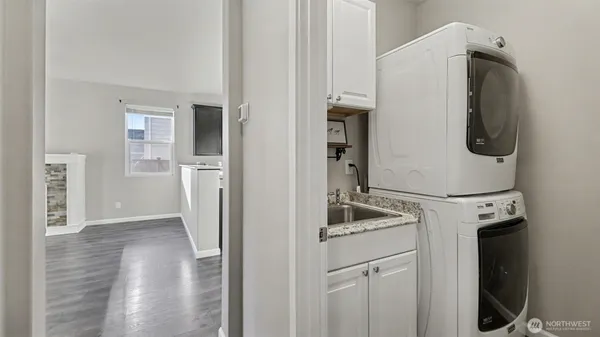 a utility room with wooden floor washer and dryer