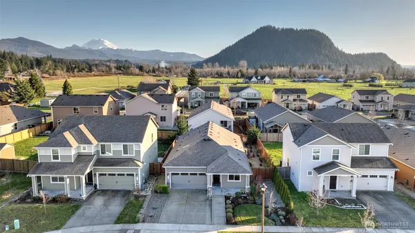 an aerial view of residential houses with outdoor space and ocean view
