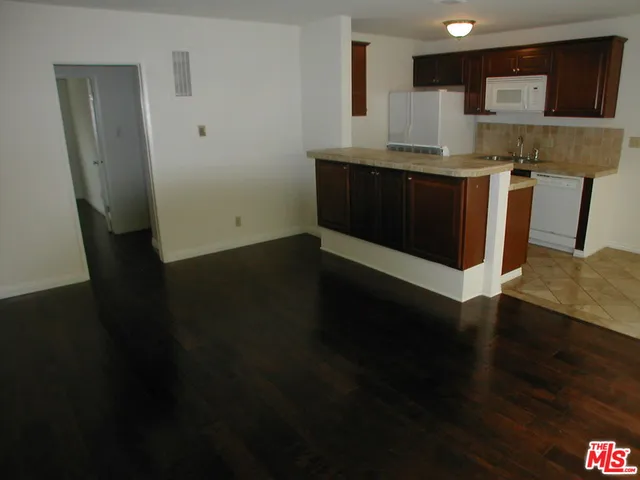 a kitchen with a sink and wooden floor