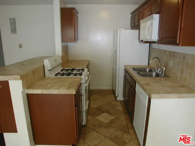 a kitchen with a sink a stove and a refrigerator