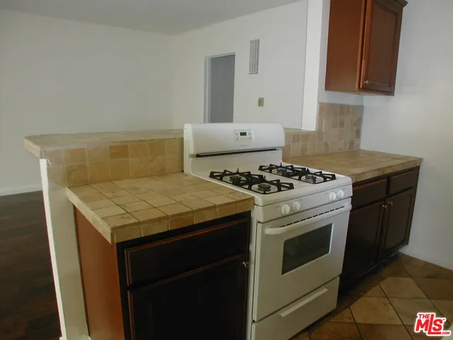 a white stove top oven sitting inside of a kitchen