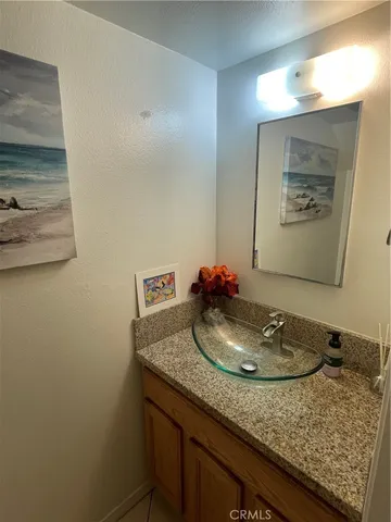a bathroom with a granite countertop sink and a mirror