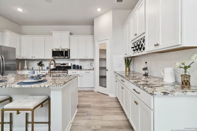 a kitchen with white cabinets and a sink