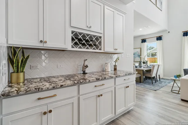 a kitchen with granite countertop a sink stainless steel appliances and white cabinets