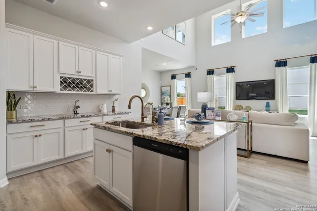 a kitchen with granite countertop white cabinets and stainless steel appliances