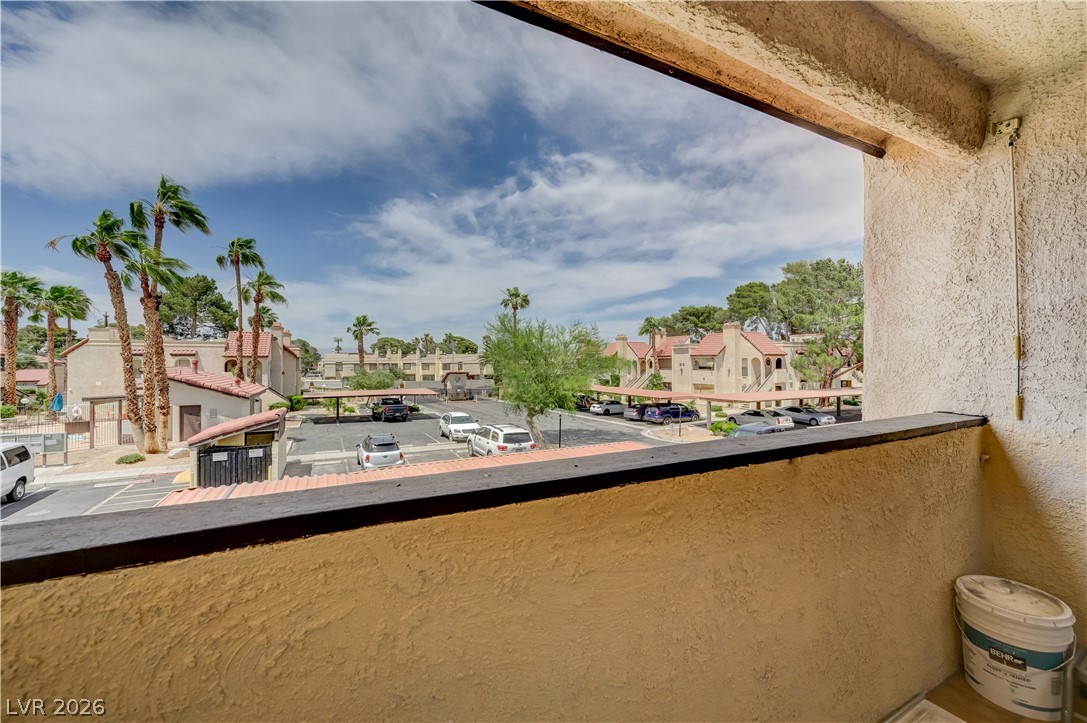 1751 East Reno Avenue, Unit 228 Las Vegas, NV 89119 - Photo 30 of 39 Bask in expansive views from this private balcony, overlooking a vibrant community with ample parking.