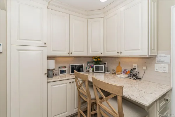 a kitchen with a sink a stove and white cabinets