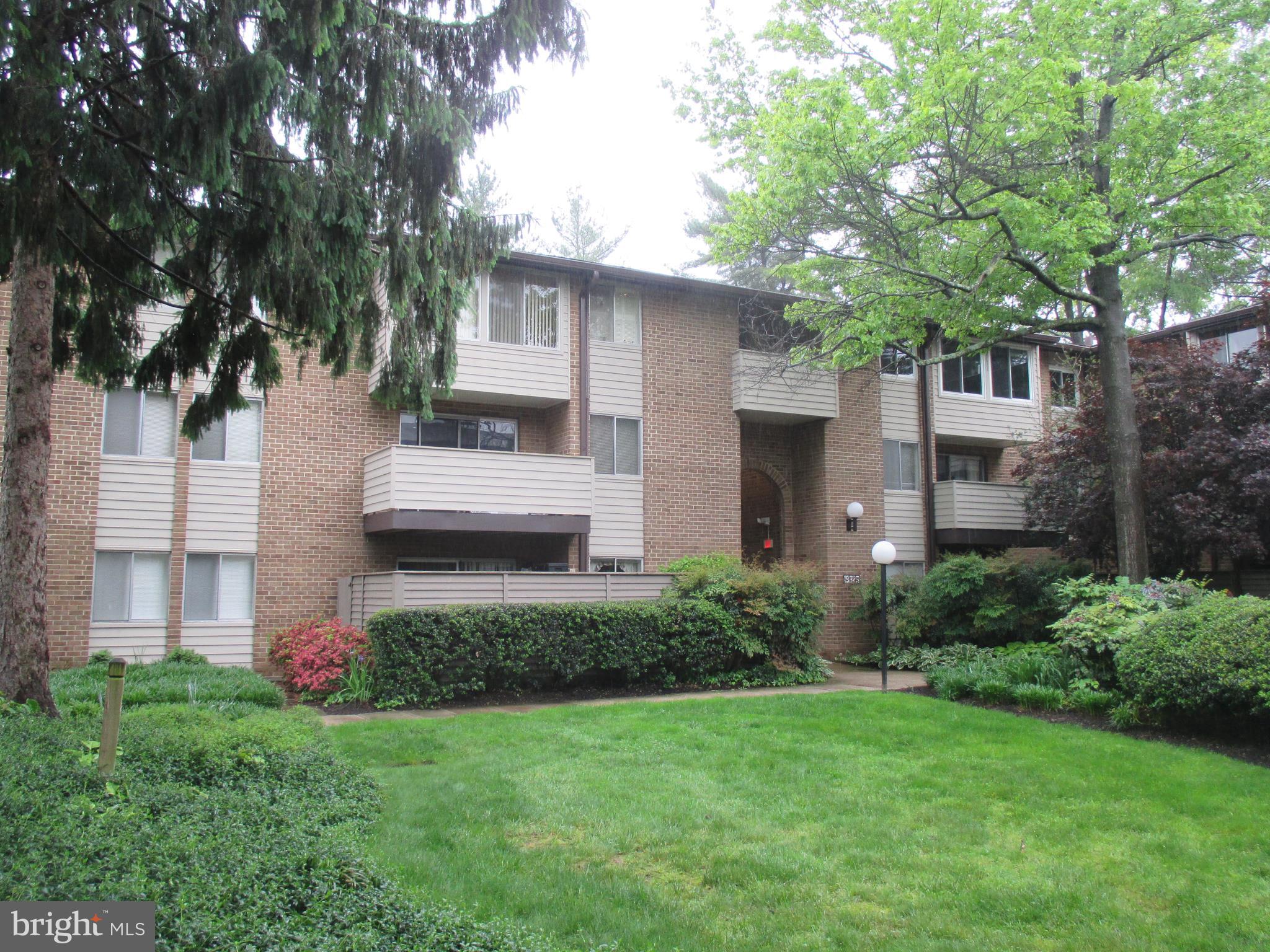 19317 Club House Road, Unit 302 Gaithersburg, MD 20886 - Photo 3 of 18 a front view of a house with a yard and trees