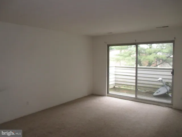 a view of empty room with stairs and balcony
