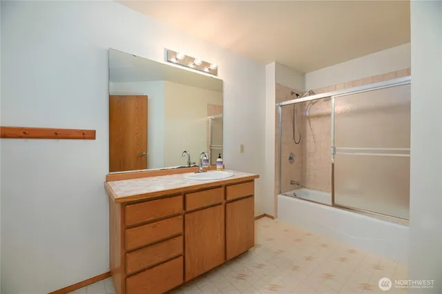 a bathroom with a double vanity sink mirror and shower