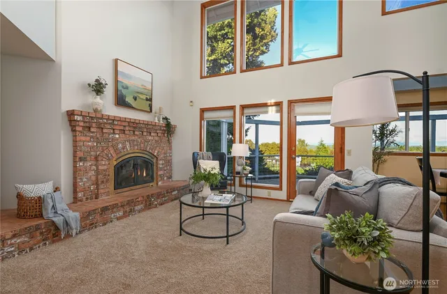 a living room with furniture a fireplace and a floor to ceiling window