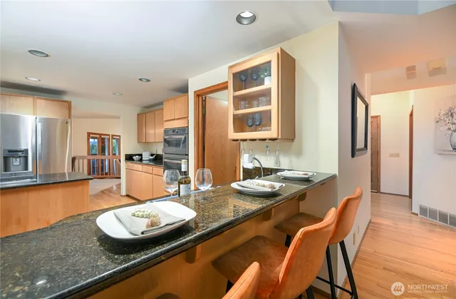 a kitchen with sink refrigerator dining table and chairs