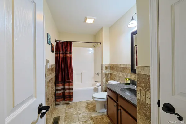 a bathroom with a double vanity sink toilet and shower