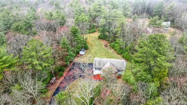 an aerial view of a house with a yard and large trees