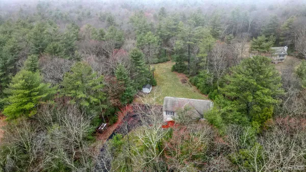 an aerial view of a house with a yard and tree s