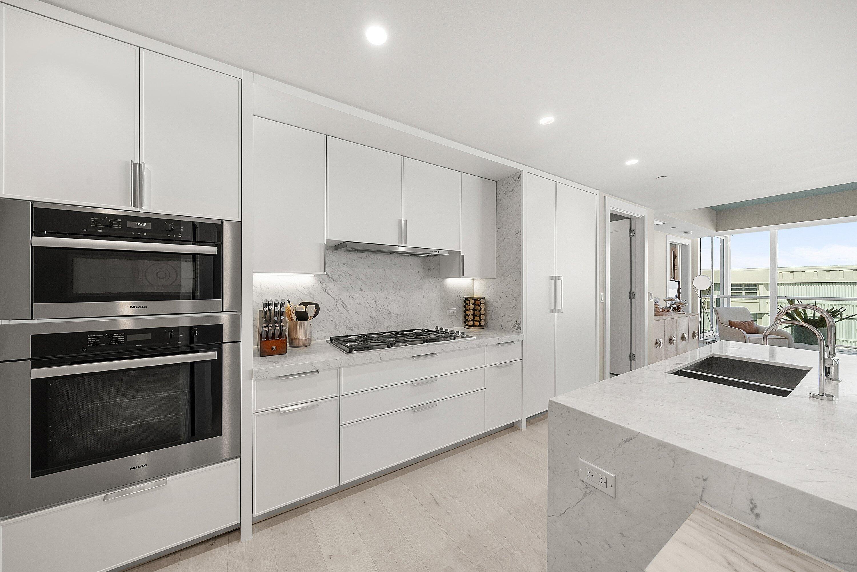 3550 South Ocean Boulevard, Unit 7C South Palm Beach, FL 33480 - Photo 15 of 66 a kitchen with granite countertop white cabinets and stainless steel appliances
