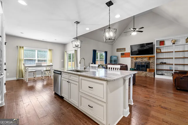 a large kitchen with cabinets a counter space a sink and wooden floor