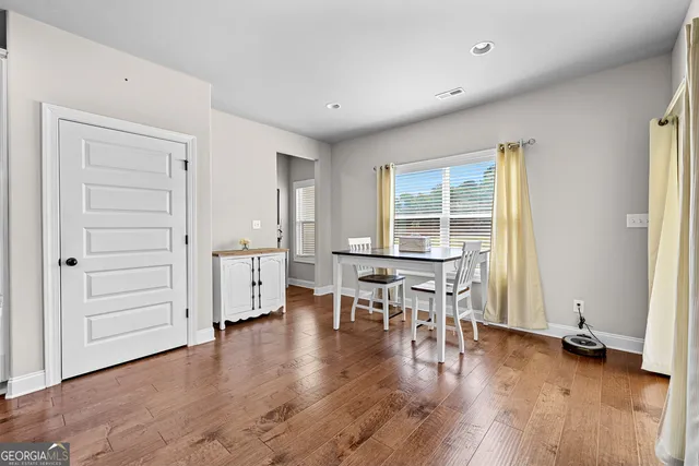 an empty room with wooden floor and furniture