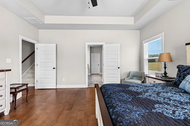 a bedroom with a large bed and wooden floor