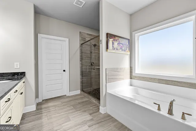 a spacious bathroom with a granite countertop tub sink and mirror