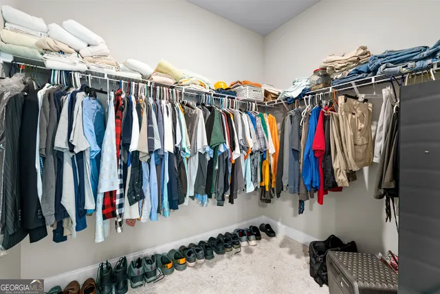 a view of walk in closet with clothes