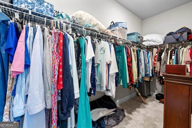 a view of walk in closet with clothes
