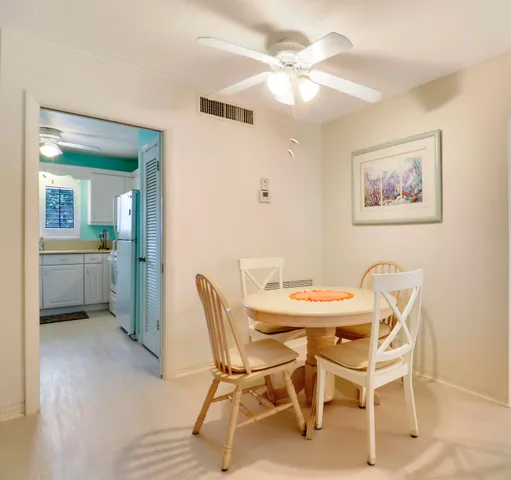 a view of a dining room with furniture and a chandelier fan