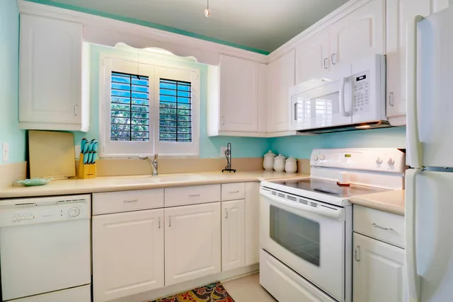 a kitchen with cabinets appliances a sink and a window
