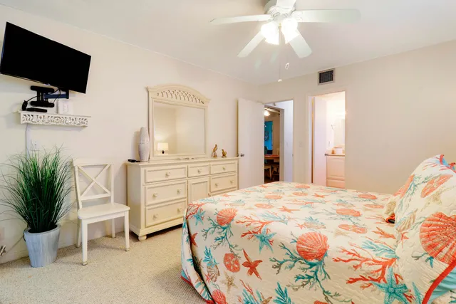 a spacious bedroom with a bed and a flat screen tv