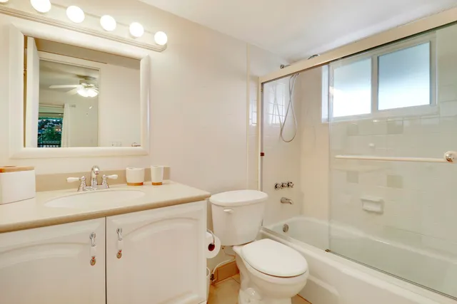 a bathroom with a granite countertop toilet sink and a mirror