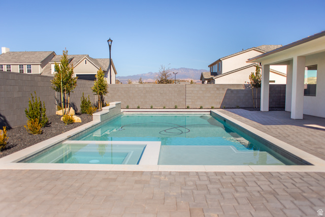 4658 South 380 East Washington, UT 84780 - Photo 4 of 10 Integrated pool / hot tub featuring a fenced backyard, a patio area, and a mountain view