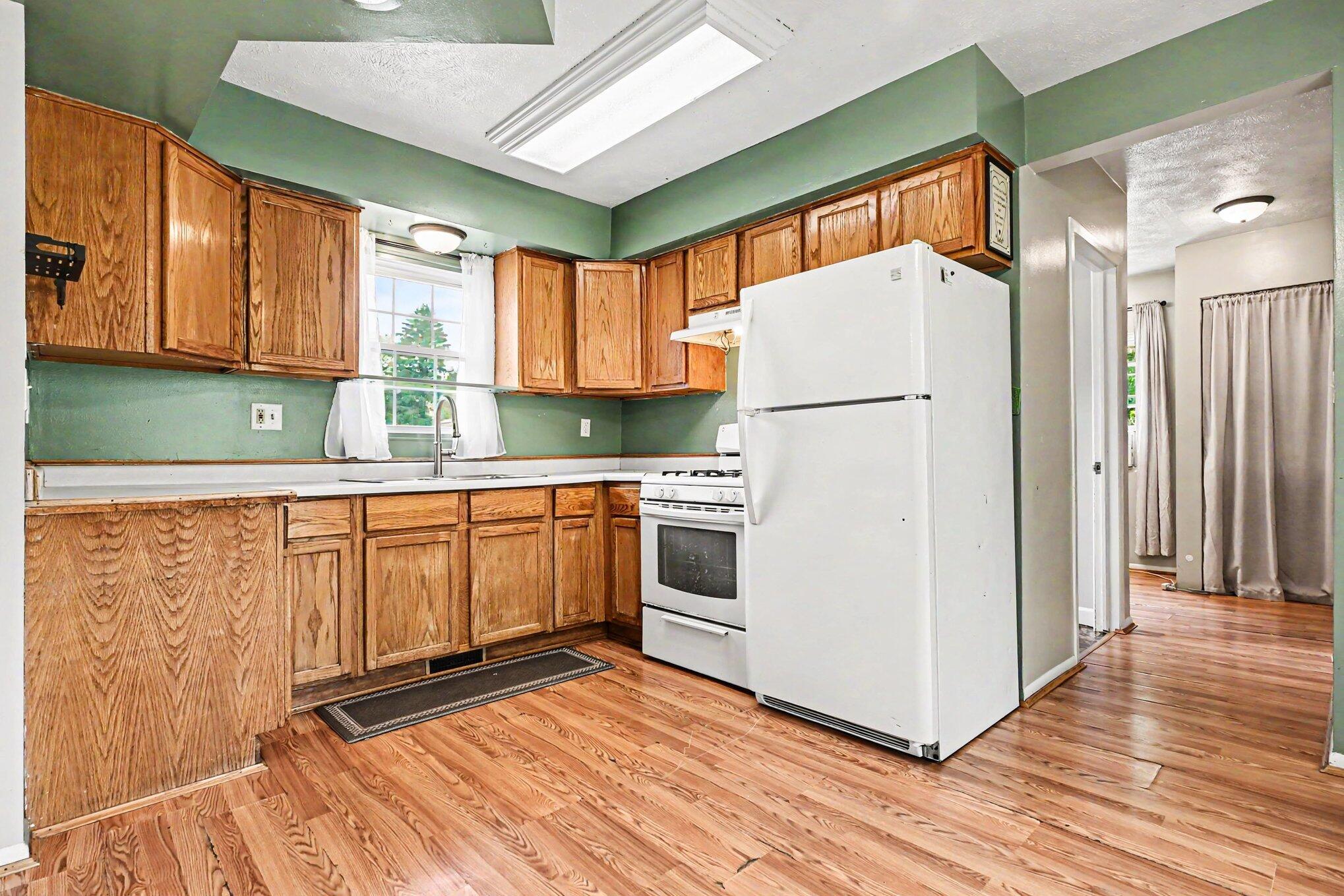 115 McClung Road La Porte, IN 46350 - Photo 7 of 31 a kitchen with granite countertop a refrigerator a sink and white cabinets
