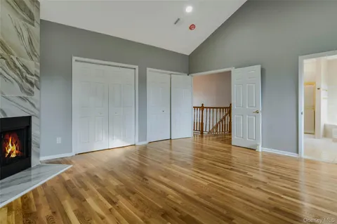 a view of empty room with wooden floor and fireplace