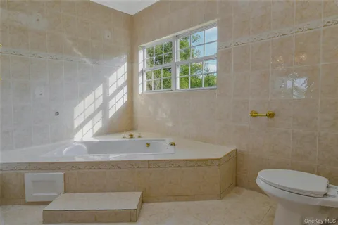 a spacious bathroom with a granite countertop double vanity sink and a mirror