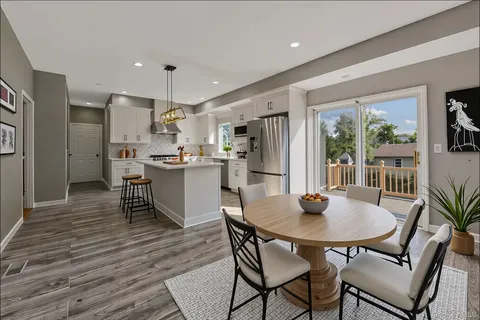 a kitchen with a dining table chairs and refrigerator