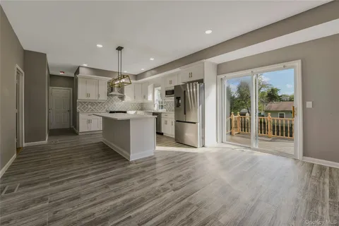 a large kitchen with stainless steel appliances granite countertop a refrigerator and a stove top oven