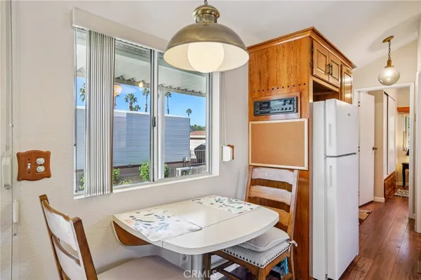 a kitchen that has a table chairs in it and wooden floors