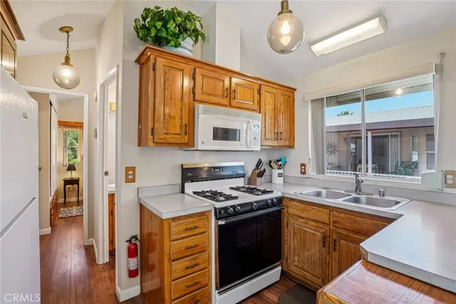 a kitchen with stainless steel appliances granite countertop a refrigerator stove a sink and a microwave