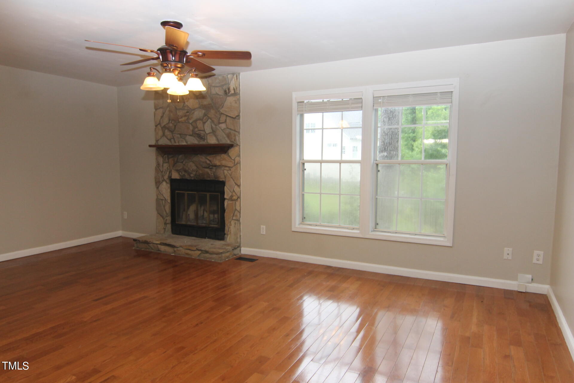 4516 Still Pines Drive Raleigh, NC 27613 - Photo 2 of 15 an empty room with wooden floor fan and windows
