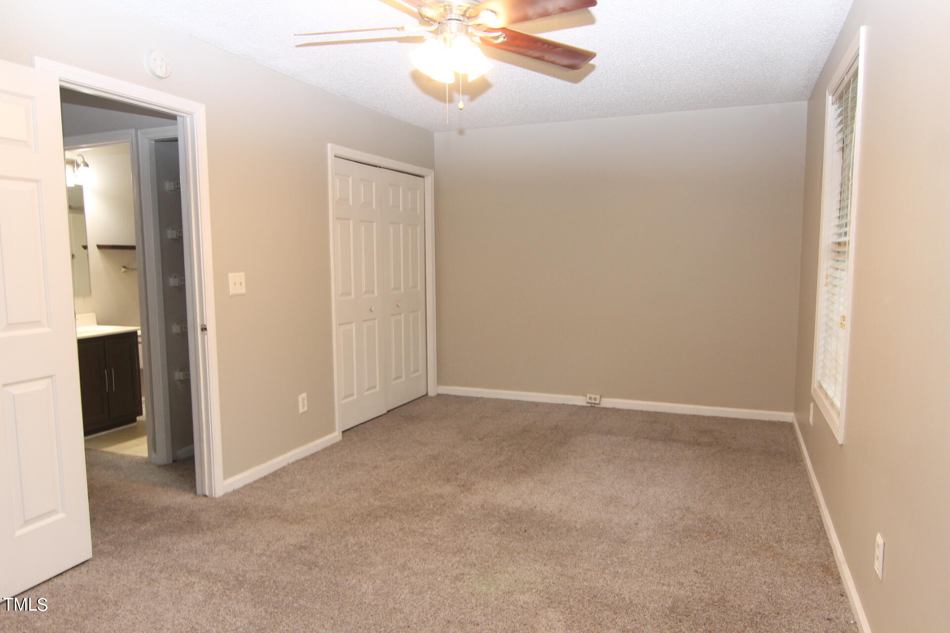 4516 Still Pines Drive Raleigh, NC 27613 - Photo 7 of 15 an empty room with a chandelier fan and a bathroom