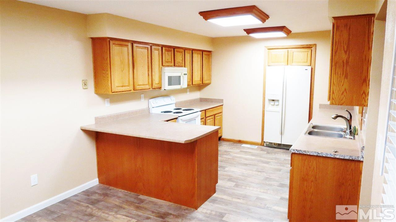 6525 Lotus Street Reno, NV 89506 - Photo 5 of 25 a kitchen with granite countertop a sink and a stove